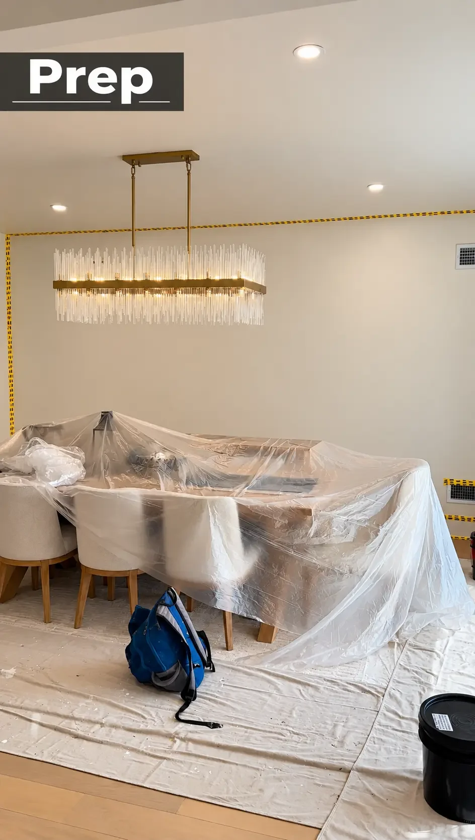 Dining table and chairs covered with plastic, wall edges taped and floor protected before plaster application — Ridgewood, NJ