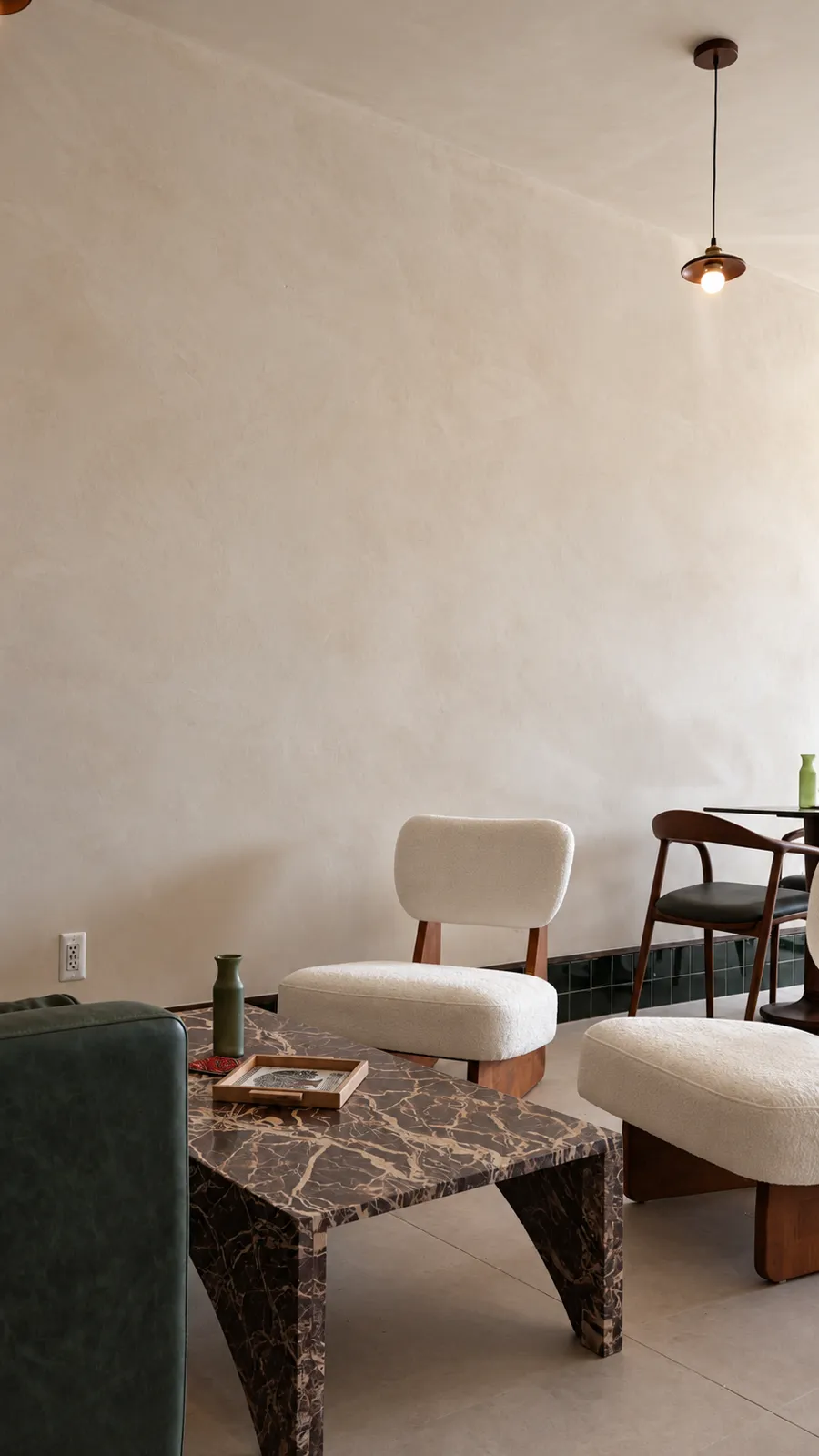 Soft ivory limewash wall and ceiling above a marble table and boucle lounge chairs at Coffiyeh coffee shop in Clifton, NJ