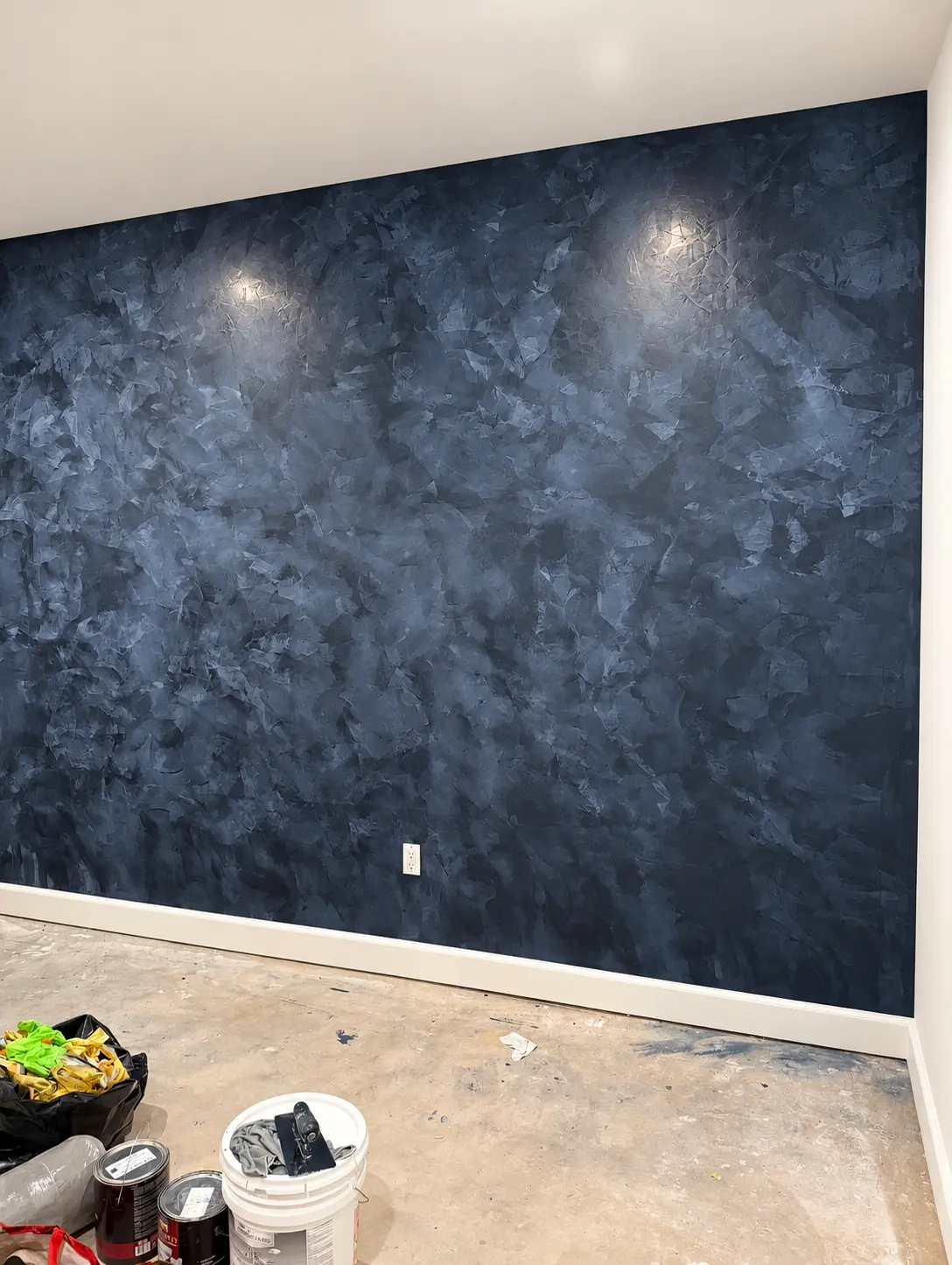 Deep navy Venetian plaster feature wall with burnished movement in a North Jersey home
