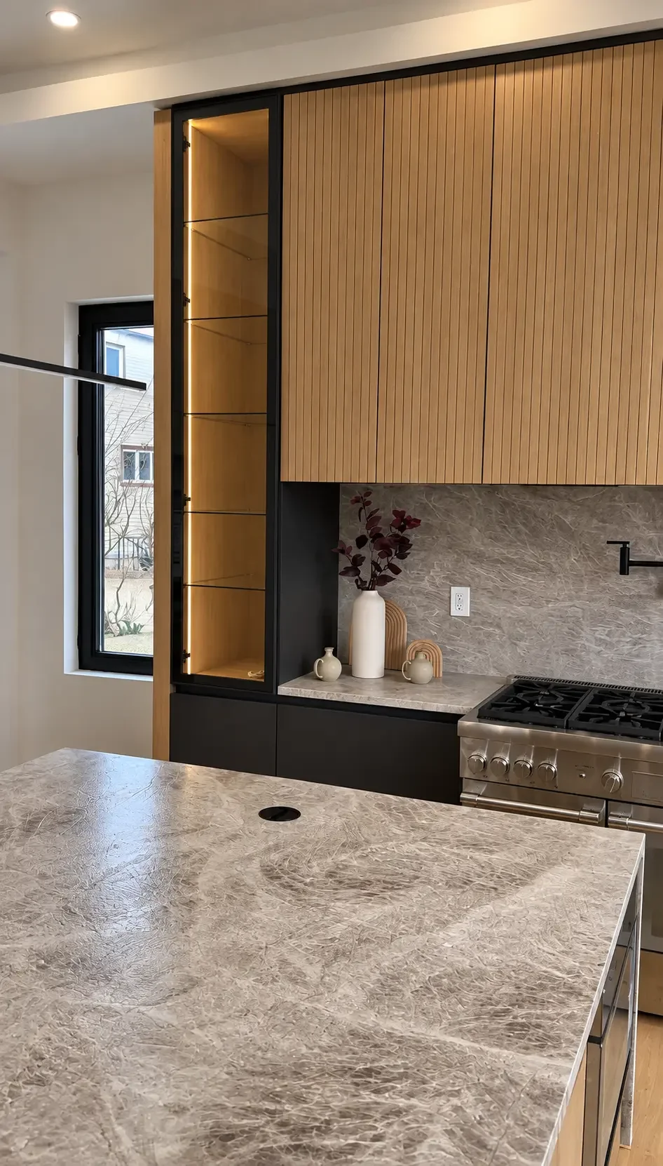 Paramus kitchen with tall wood cabinetry, stone island and finely finished ceiling