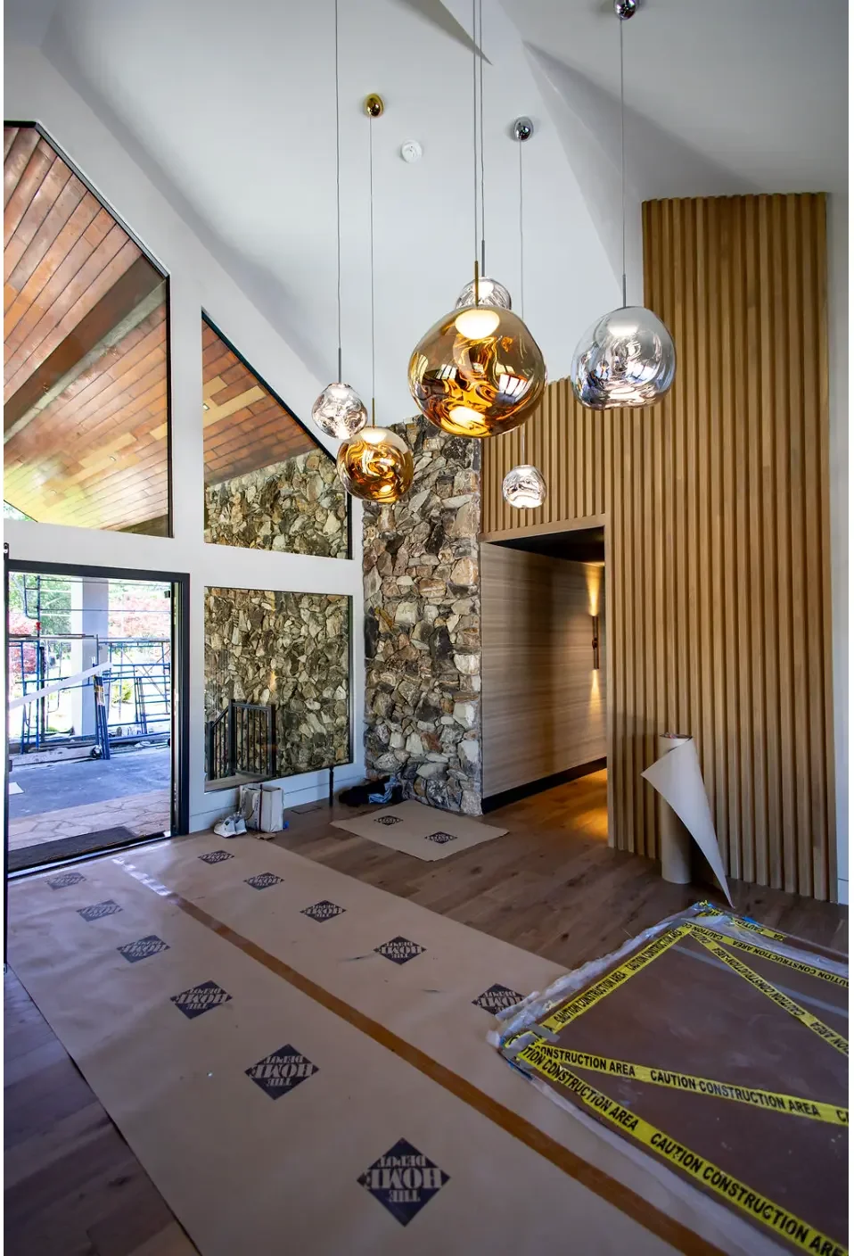 Foyer in progress with wood slat feature wall beside a stone fireplace in Pompton Plains, NJ