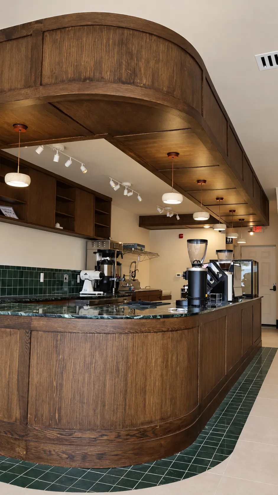 Curved coffee bar counter in newly stained wood with green marble top at Coffiyeh coffee shop in Clifton, NJ