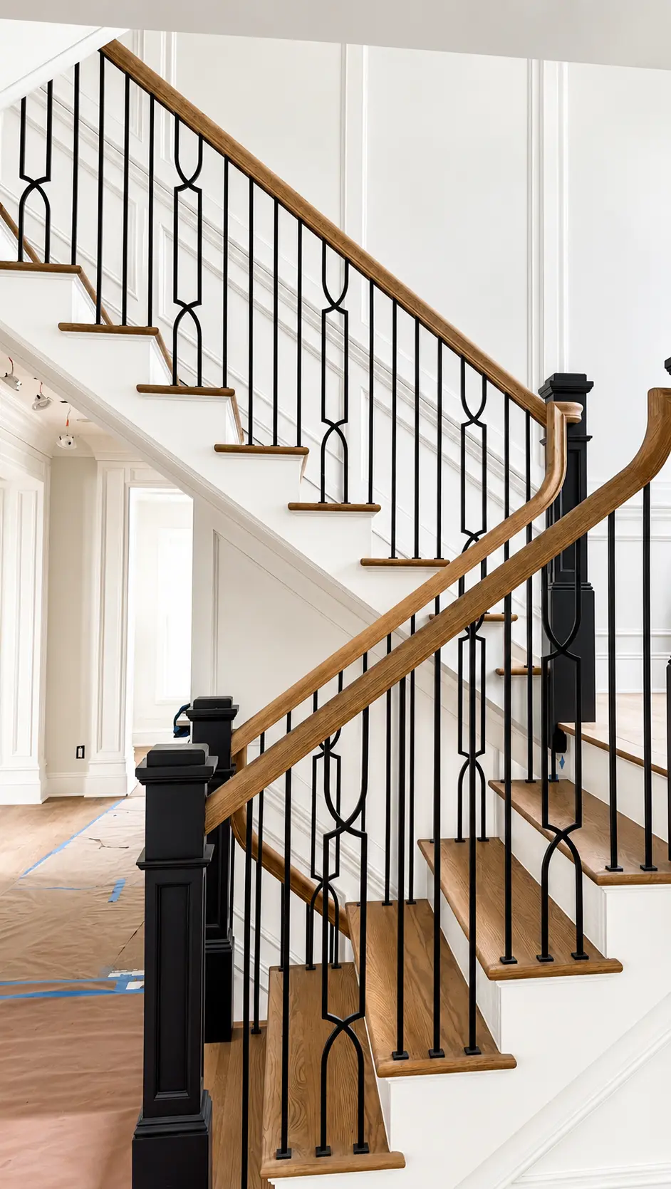 Finished wood staircase treads and handrails with black iron balusters