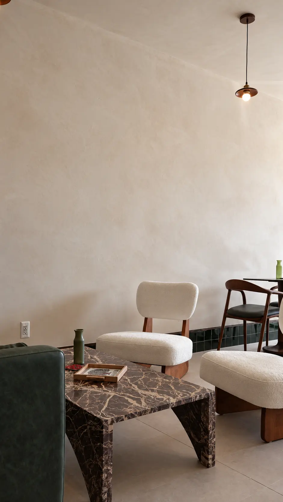 Soft mineral movement on a limewash lounge wall above a marble coffee table and boucle chairs in Clifton, NJ