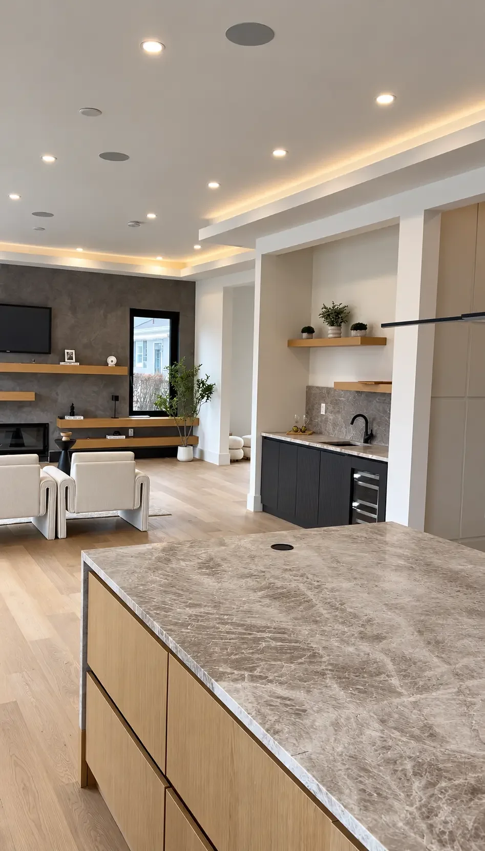Open-concept Paramus kitchen with painted ceiling, wood cabinetry and adjoining living area
