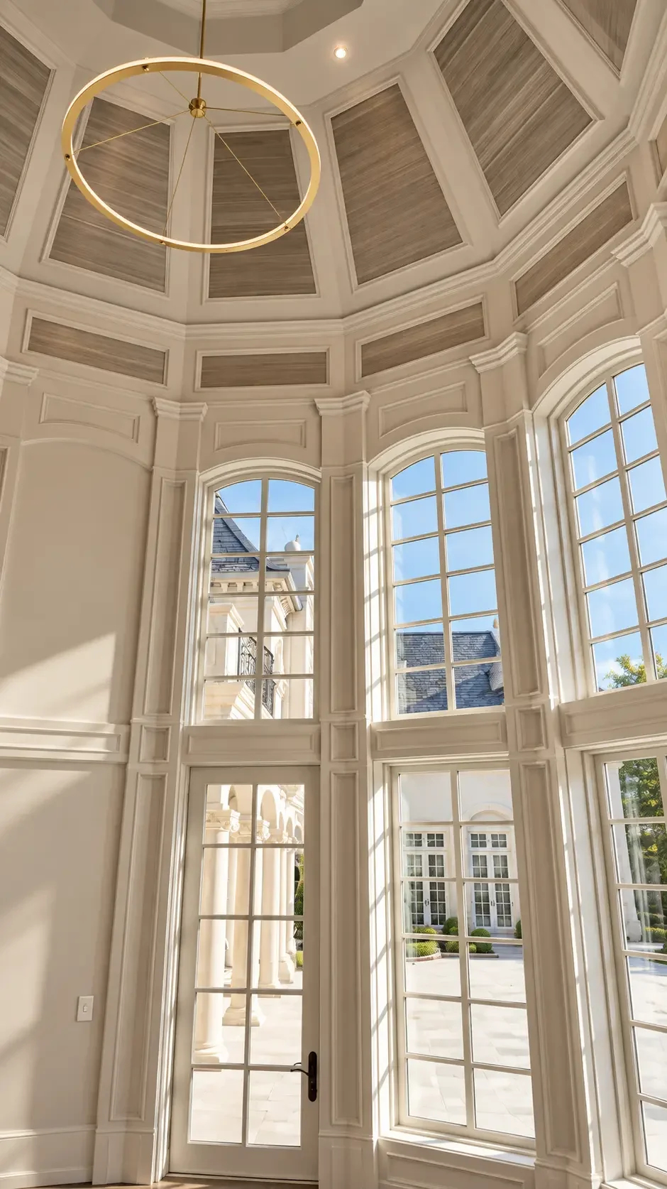 Round room with grasscloth ceiling panels and tall arched windows in Alpine, NJ