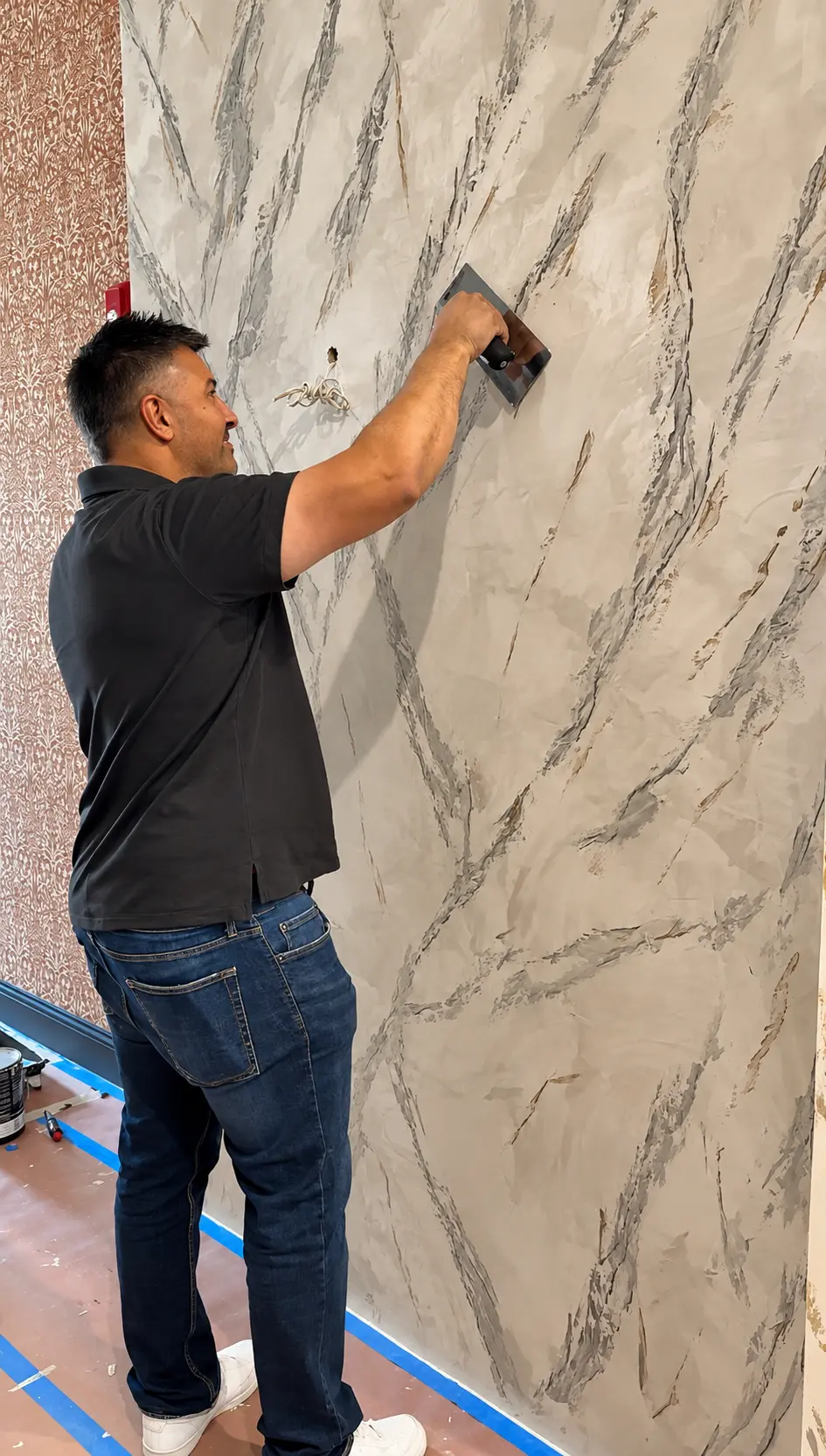 Artisan trowelling a marble-look Venetian plaster wall finish in North Jersey