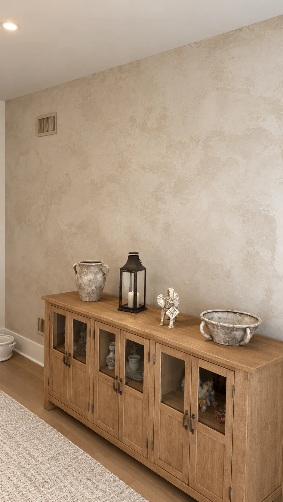 Finished Swiss Coffee plaster wall with ceramic urn, lantern and bowl on the wooden sideboard — Ridgewood, NJ