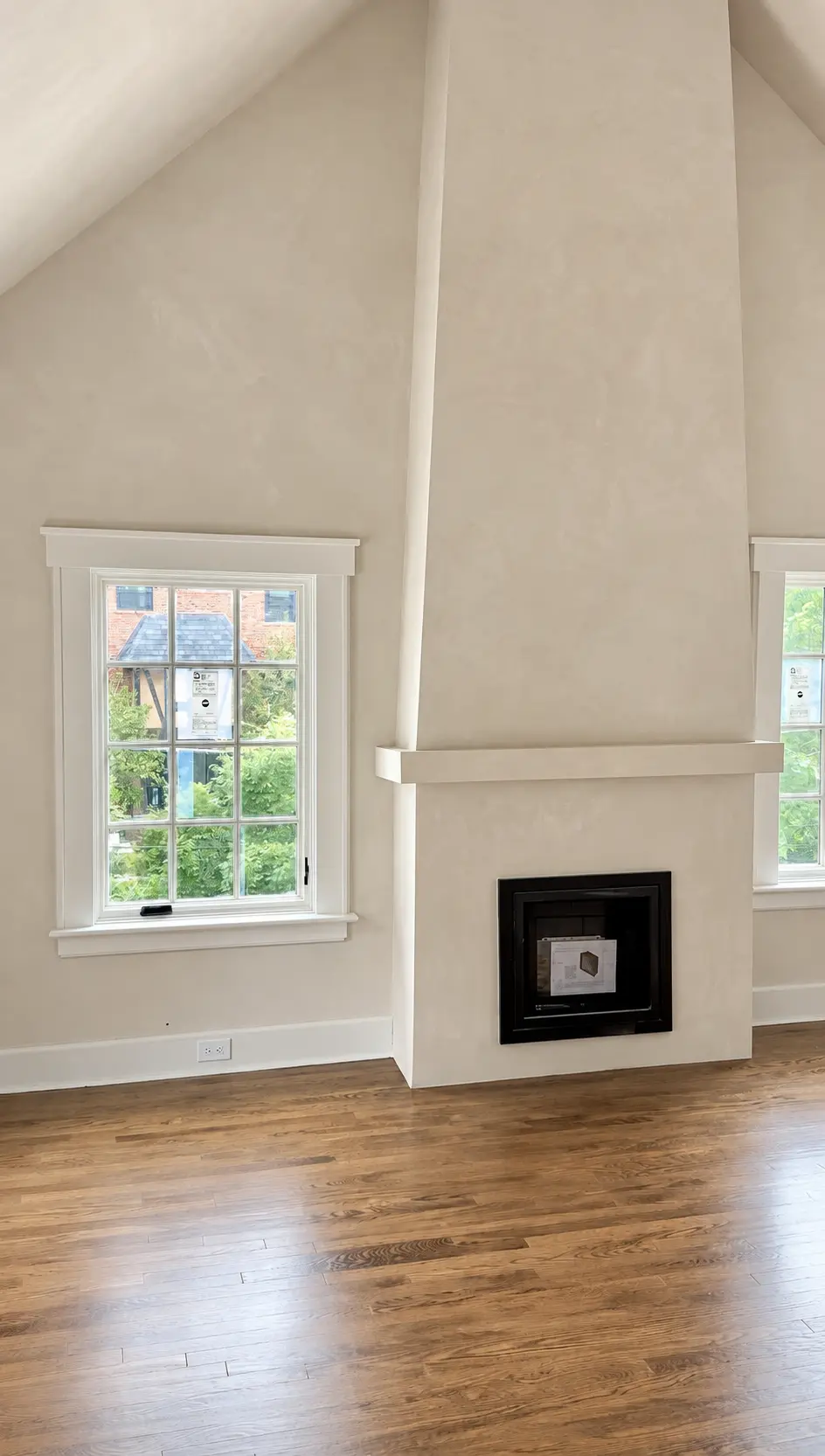 Tall fireplace feature wall finished in a subtle warm limewash with natural tonal movement