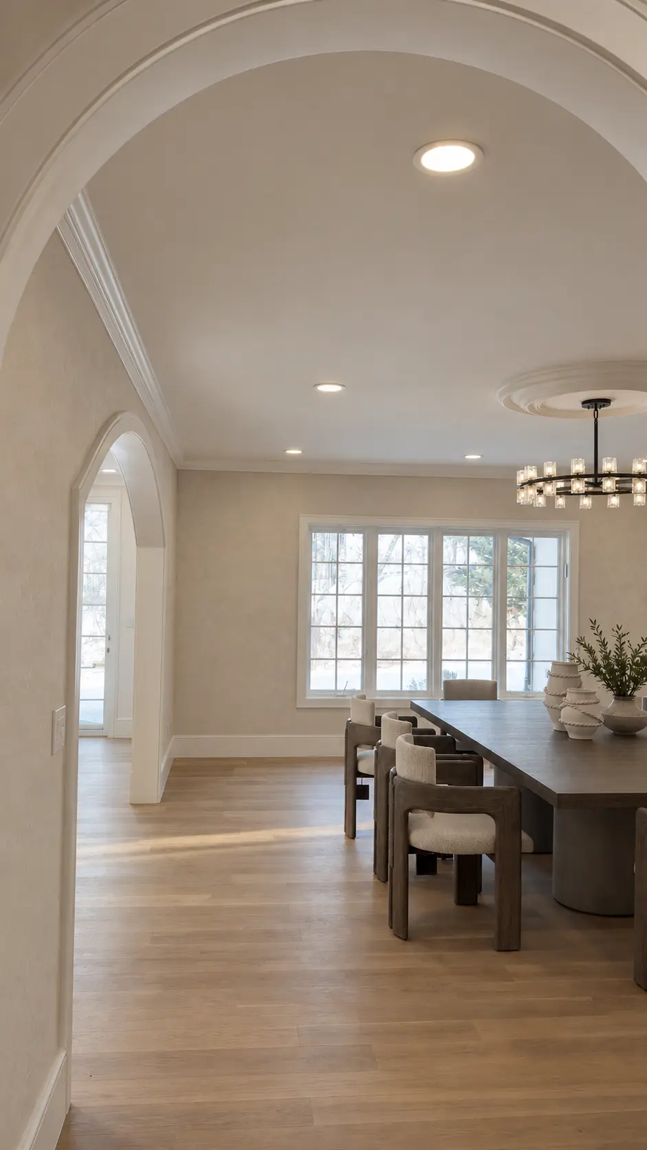 Dining room with arched openings and softly textured neutral limewash walls
