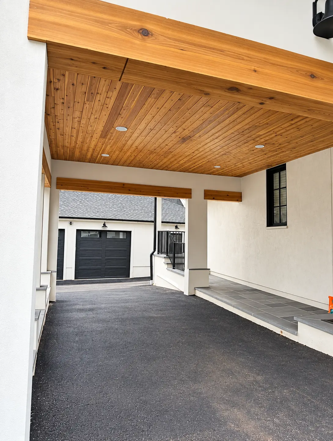 Finished natural wood ceiling and beams over a covered driveway