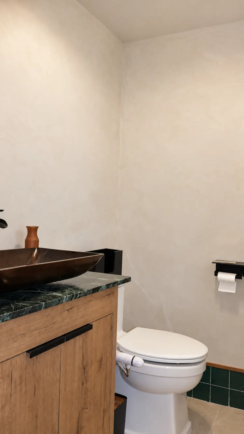 Limewash restroom walls above a green marble vanity with copper vessel sink in a Clifton, NJ coffee shop