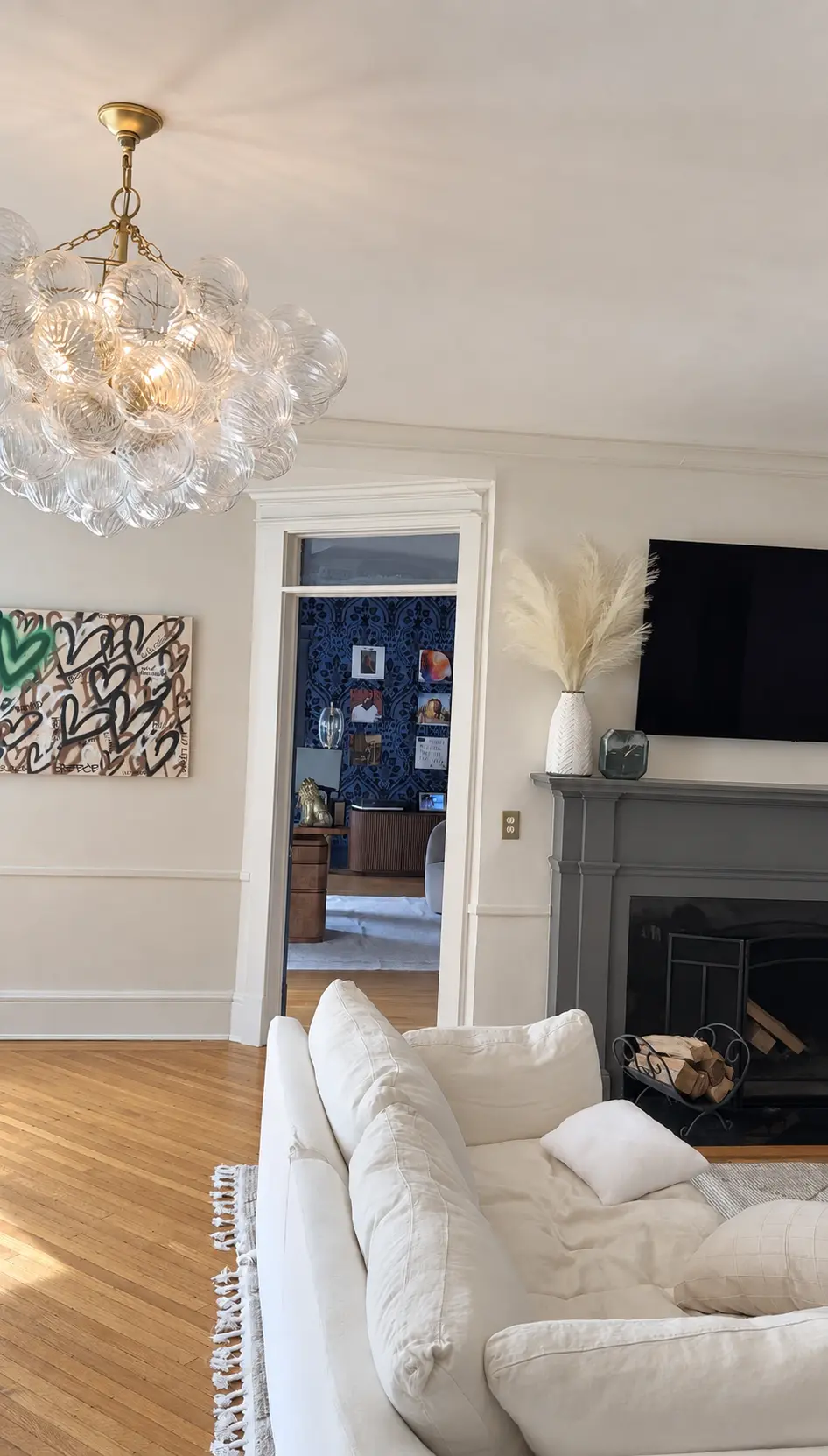 Finished living room with soft neutral limewash across the walls and ceiling surrounding a dark fireplace