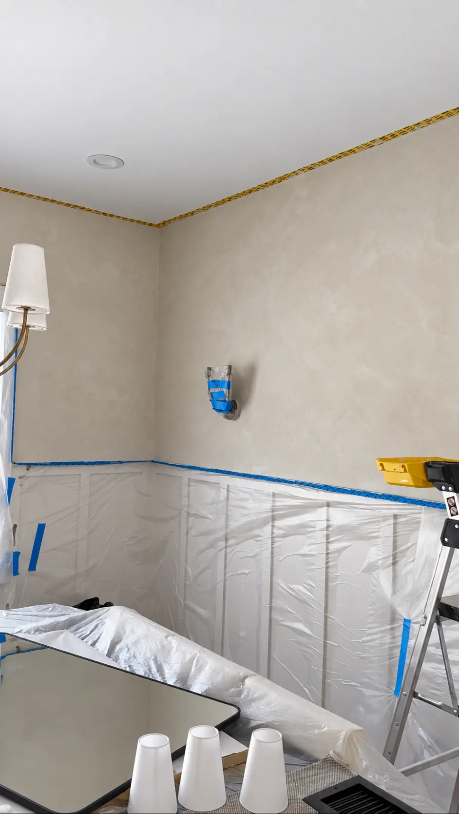 Interior limewash project in progress with lower wall panels protected while the upper walls receive the finish