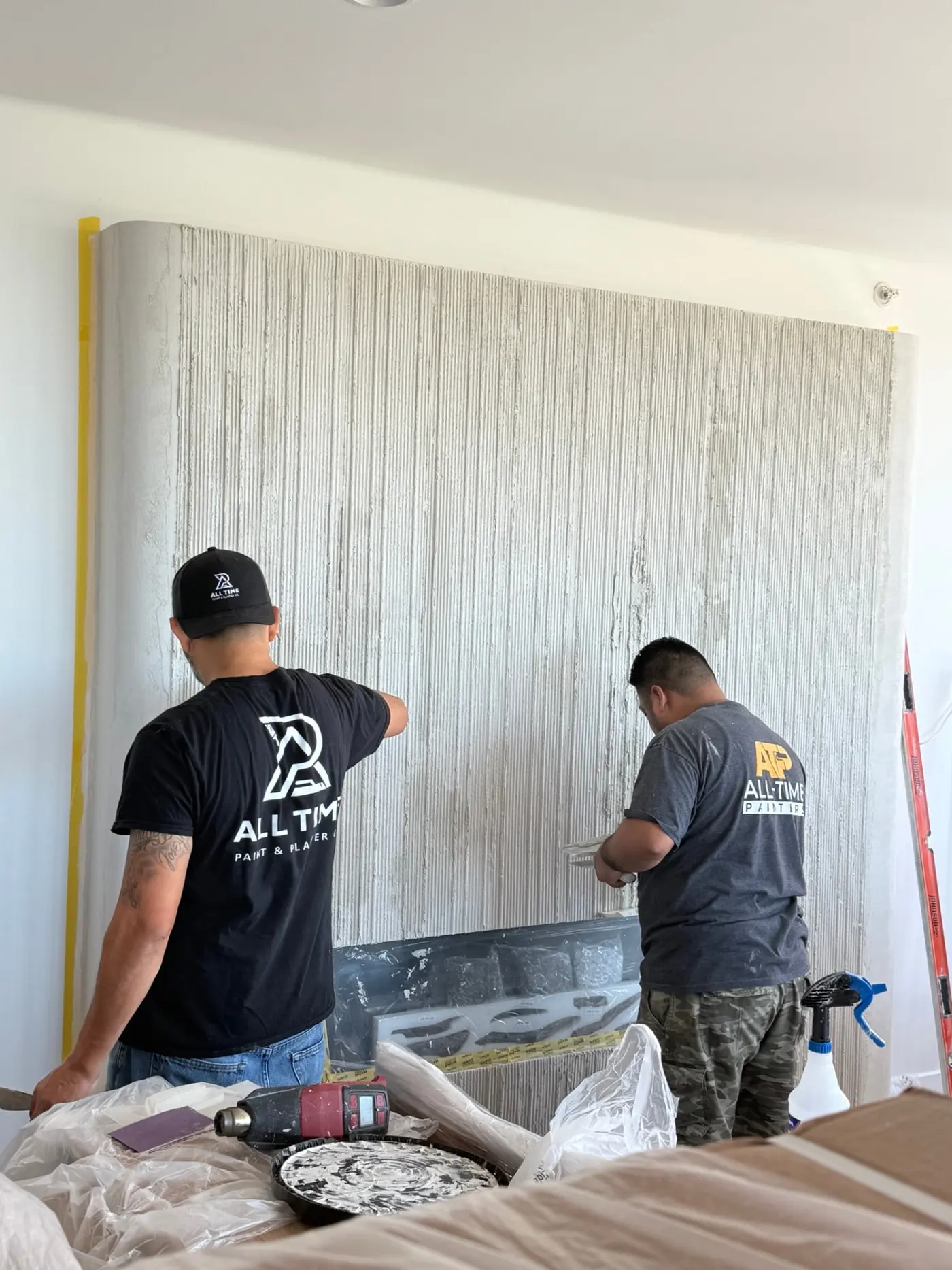 All Time Paint & Plaster artisans hand-combing vertical flutes into fresh Meoded Marmorino Intonaco plaster on a New Brunswick, NJ fireplace wall