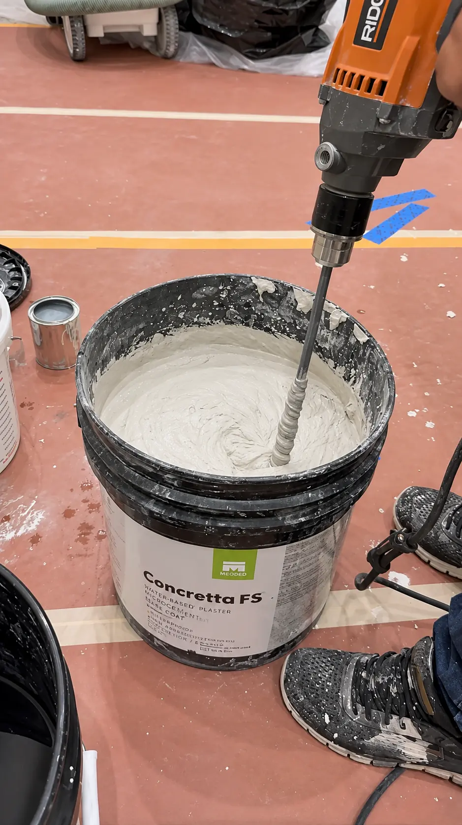 Meoded Concretta FS water-based microcement base coat being power-mixed on site for a commercial retail counter installation in Clifton, NJ