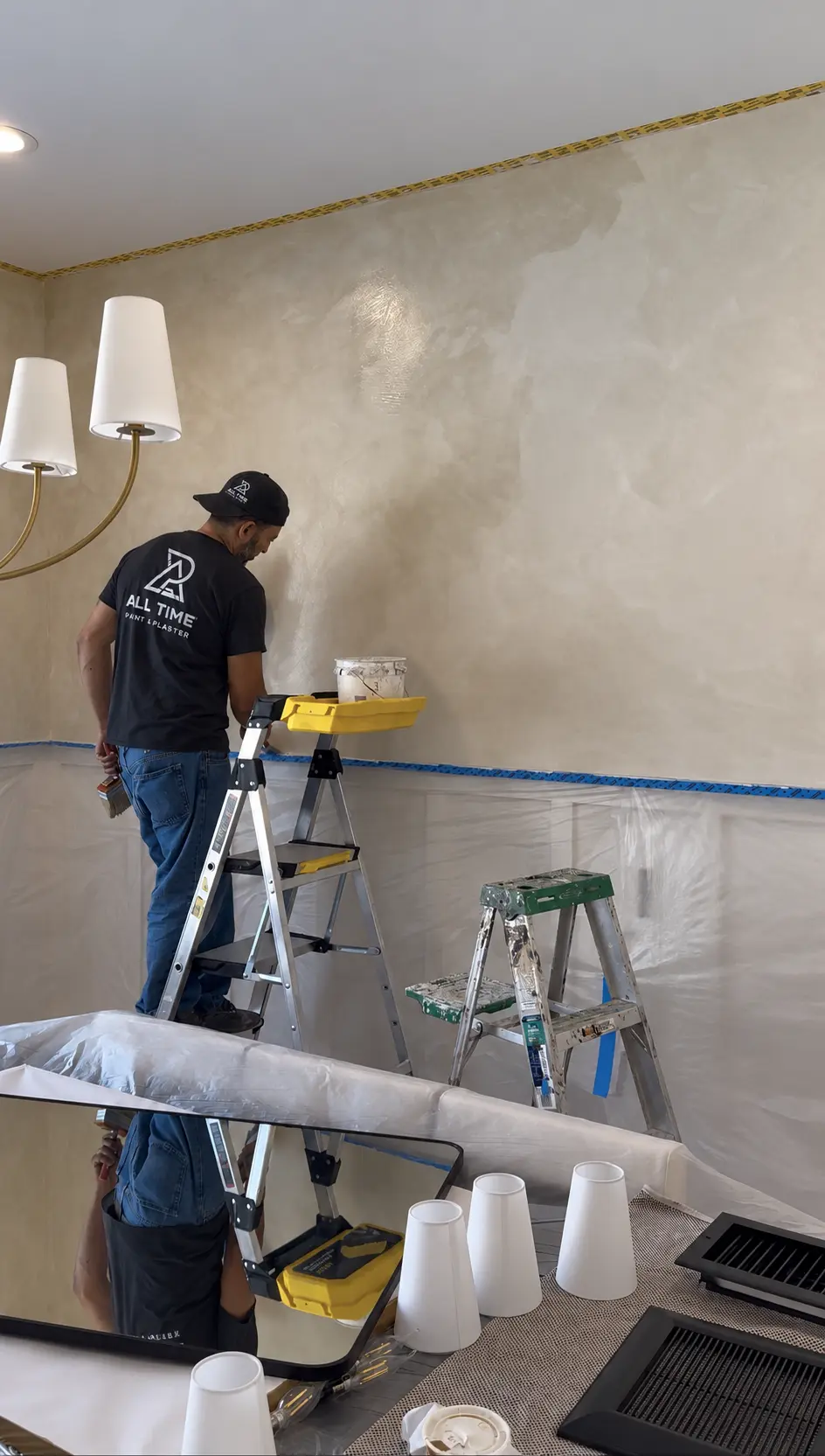All Time Paint & Plaster craftsman hand brushing limewash onto a protected interior wall