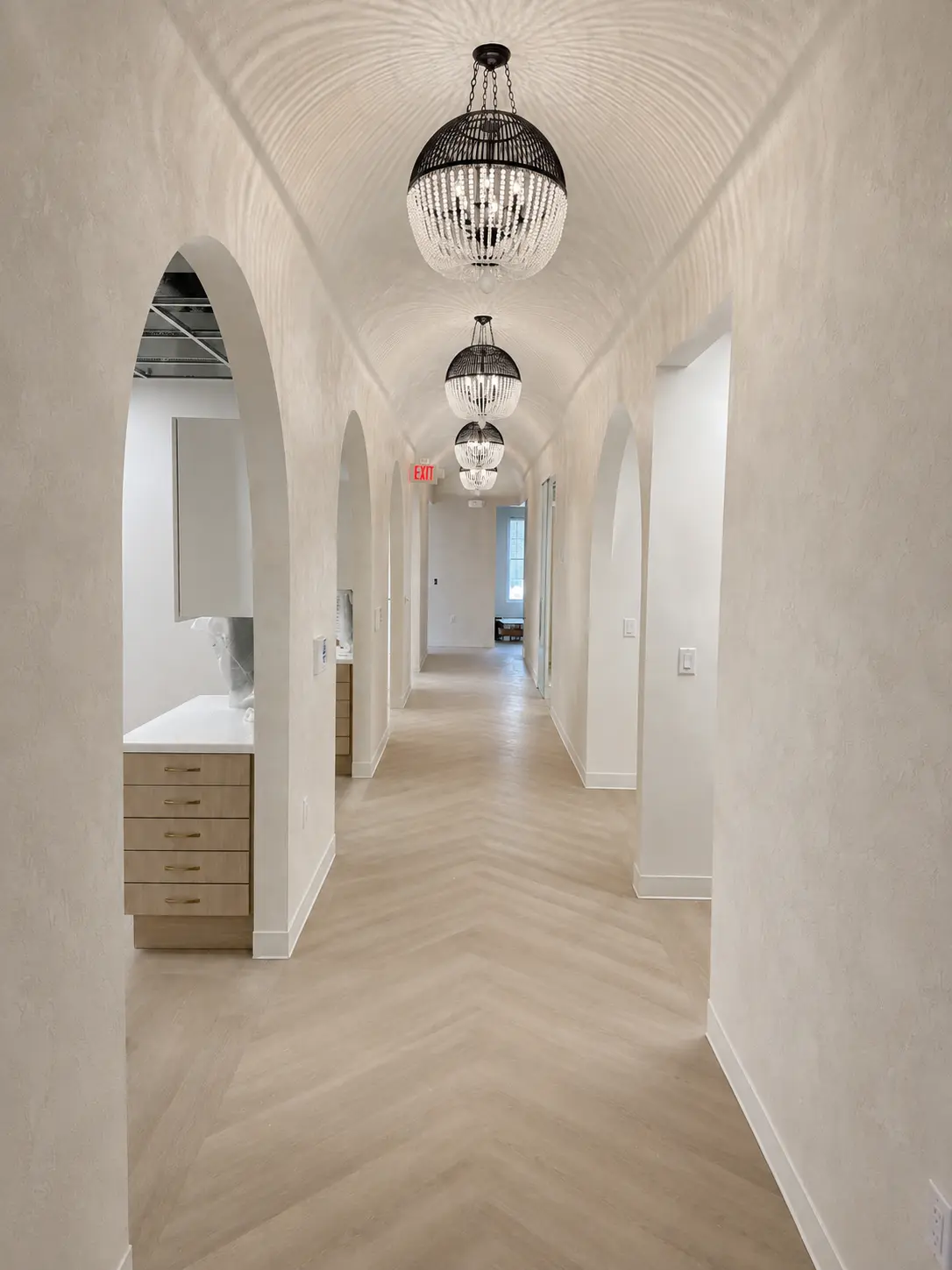 Palladino plaster barrel-vault hallway with arched openings and crystal chandeliers in the Oakwell Dental Office in Warren, NJ