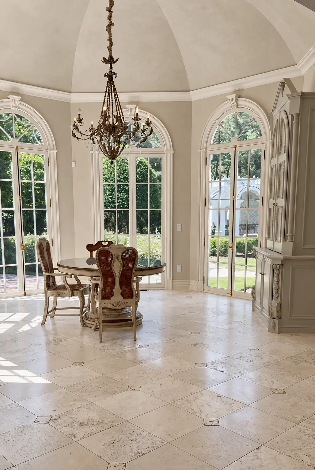 Domed breakfast room ceiling and walls finished in warm neutral limewash with arched French doors in Franklin Lakes, NJ