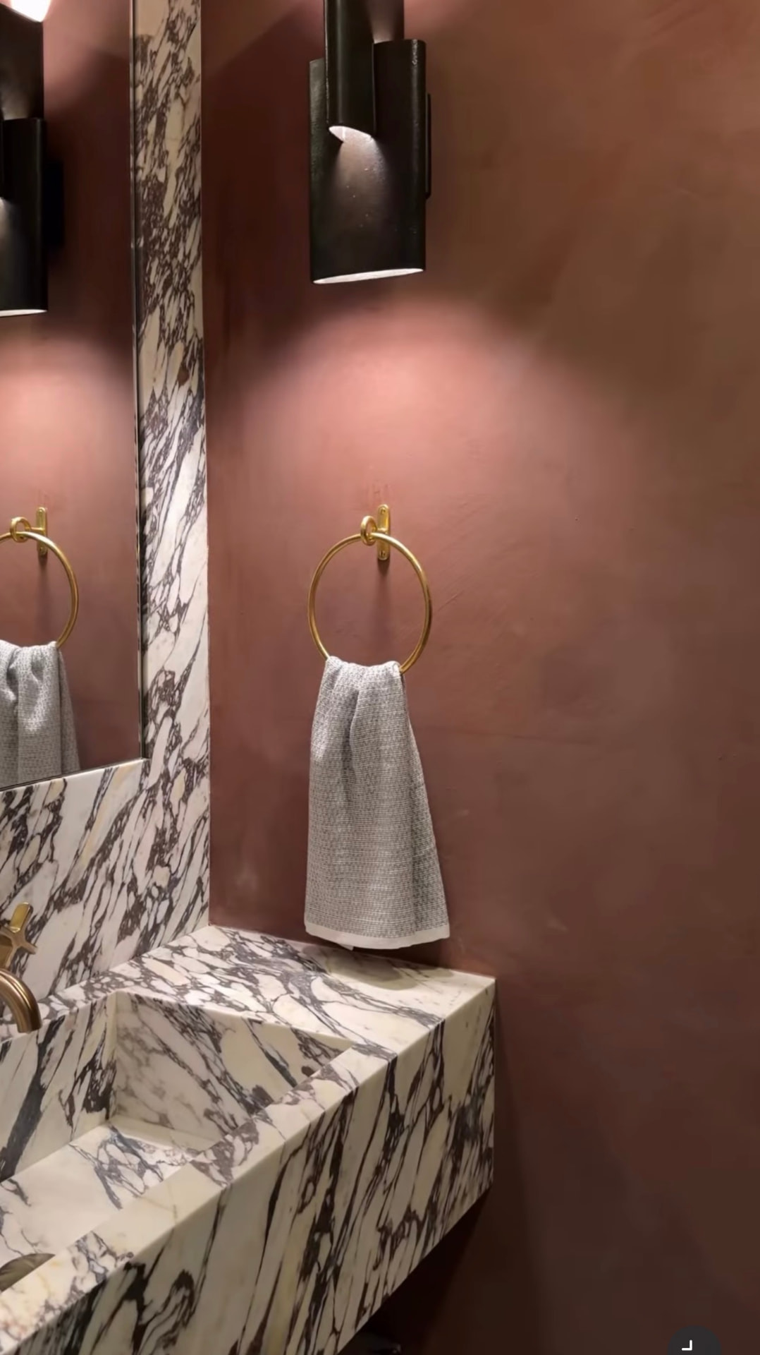 Terracotta limewash powder room walls with a Calacatta Viola marble sink and brass towel ring in Montclair, NJ